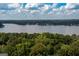 Expansive aerial view of a serene lake bordered by dense forests, reflecting a partly cloudy sky at 148 Lakeside Dr, Peachtree City, GA 30269