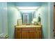 Bathroom with wooden vanity, granite countertops and custom mirror at 148 Lakeside Dr, Peachtree City, GA 30269