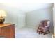 Cozy bedroom with a wooden dresser and a wingback chair at 148 Lakeside Dr, Peachtree City, GA 30269