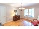 Bright dining room with hardwood floors, chandelier lighting, and a view of the serene outdoor setting at 148 Lakeside Dr, Peachtree City, GA 30269