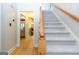 Inviting foyer featuring hardwood floors, stairs with carpet runner, and an open doorway to the living area at 148 Lakeside Dr, Peachtree City, GA 30269