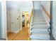 Inviting entryway featuring hardwood floors, stairs with carpet runner, and an open doorway to the living area at 148 Lakeside Dr, Peachtree City, GA 30269