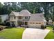 Two-story home with a neatly landscaped front yard, charming front porch and three car garage at 148 Lakeside Dr, Peachtree City, GA 30269