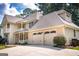 Side view of the home showing a three car garage and neatly manicured lawn at 148 Lakeside Dr, Peachtree City, GA 30269