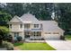 Charming two-story home featuring a spacious front porch, three-car garage, and beautifully landscaped front yard at 148 Lakeside Dr, Peachtree City, GA 30269