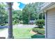 View of the manicured front lawn and the traditional-style home with mature trees in the neighborhood at 148 Lakeside Dr, Peachtree City, GA 30269