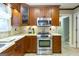 A kitchen includes stainless steel appliances, wood cabinets, granite counters, and tile backsplash at 148 Lakeside Dr, Peachtree City, GA 30269