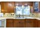 A kitchen is furnished with granite counters, wood cabinets and floors, stainless steel appliances, and a window at 148 Lakeside Dr, Peachtree City, GA 30269