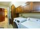 The laundry room features a white washer and dryer, wooden cabinets, and granite countertops at 148 Lakeside Dr, Peachtree City, GA 30269