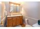 A classic powder room featuring a wood vanity, countertop, and elegant mirror with built-in lighting at 148 Lakeside Dr, Peachtree City, GA 30269