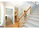 A well-lit foyer showcases a staircase with carpeted steps and natural wood railing and trim throughout at 148 Lakeside Dr, Peachtree City, GA 30269