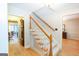 A bright foyer features hardwood floors and a staircase with carpeted steps and natural wood railing at 148 Lakeside Dr, Peachtree City, GA 30269