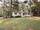 Charming one-story white home with black shutters and a well-maintained front yard with mature shade trees at 10103 Allen Sw Dr, Covington, GA 30014