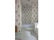 Bathroom featuring floral wallpaper, white hexagonal tile, and a glass shower door at 1448 Se Hillside Place, Conyers, GA 30094