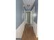 Hallway with blue walls, white trim, and wood-look laminate flooring at 1448 Se Hillside Place, Conyers, GA 30094
