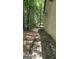Image features the side of the house and the surrounding wooded land at 1448 Se Hillside Place, Conyers, GA 30094