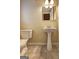 Simple bathroom featuring a pedestal sink and classic tile flooring, complemented by neutral-toned walls at 3681 Chestnut Lake Ct, Jonesboro, GA 30236