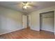 Bedroom with hardwood floors, ceiling fan, neutral walls, and closet at 3681 Chestnut Lake Ct, Jonesboro, GA 30236