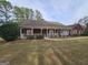 Traditional red brick home with a covered porch, complemented by trimmed bushes and mature shade trees at 164 Turner Creek Dr, Hampton, GA 30228