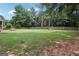 Spacious, fenced backyard with lush green grass and mature trees, perfect for outdoor activities at 320 Silverbell Ln, Sharpsburg, GA 30277