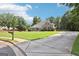Long driveway leading to a charming single-story house with well-kept lawn and mature trees at 320 Silverbell Ln, Sharpsburg, GA 30277