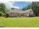 Beautiful home with green lawn, dark window shutters, and stone facade accents at 320 Silverbell Ln, Sharpsburg, GA 30277