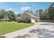 View of the attached garage with an American flag on a single-story home with stone accents and a green lawn at 320 Silverbell Ln, Sharpsburg, GA 30277