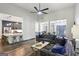 Open-concept living room featuring modern furnishings, a ceiling fan, and hardwood floors at 320 Silverbell Ln, Sharpsburg, GA 30277