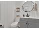 Stylish half-bathroom featuring white shiplap walls, modern gray vanity, and a round mirror for a contemporary look at 425 Birkdale Dr, Fayetteville, GA 30215