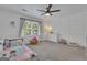 Large bedroom featuring a modern ceiling fan, bright windows, and stylish accent wall at 425 Birkdale Dr, Fayetteville, GA 30215