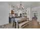 Stylish kitchen featuring white cabinets, a rustic wooden vent hood, open shelving, and a large farmhouse dining table at 425 Birkdale Dr, Fayetteville, GA 30215
