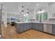 Open-concept kitchen with gray lower cabinets, white upper cabinets, an island with bar stools, and views into the living area at 425 Birkdale Dr, Fayetteville, GA 30215