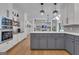 Modern kitchen with gray base cabinets, white upper cabinets, stainless appliances, and open shelving for cookbooks and decor at 425 Birkdale Dr, Fayetteville, GA 30215