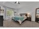 Inviting primary bedroom featuring tray ceilings, a ceiling fan, and large windows offering ample natural light at 425 Birkdale Dr, Fayetteville, GA 30215