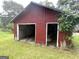 The garage has two bays, peeling paint and is overgrown with vines at 301 Wedowee St, Bowdon, GA 30108