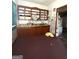 A kitchen with rustic cabinetry, shelves, and a view into another room, capturing a mix of functionality and vintage appeal at 301 Wedowee St, Bowdon, GA 30108