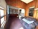 A view of the living room with wood-paneled walls, with a sofa and view into the kitchen at 301 Wedowee St, Bowdon, GA 30108