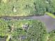 An aerial view of a home and its land, surrounded by trees and bordering a lake at 123 Eva Ln, Stockbridge, GA 30281