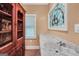 Bathroom with marble vanity, stained glass window, and adjacent to a stained wooden cabinet at 123 Eva Ln, Stockbridge, GA 30281