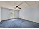 Bedroom with a ceiling fan, window with white shutter style blinds and blue carpet at 123 Eva Ln, Stockbridge, GA 30281