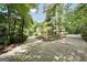 Long, winding driveway approaching a home surrounded by lush trees and greenery at 123 Eva Ln, Stockbridge, GA 30281