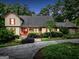 Charming home showcasing a mix of stone and wooden accents, highlighted by a red door and vibrant landscaping at 123 Eva Ln, Stockbridge, GA 30281