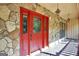 Close-up of a vibrant red front door with glass panels and stone accents at 123 Eva Ln, Stockbridge, GA 30281