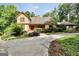 Charming home exterior with a stone and wood facade, beautiful landscaping, and a spacious driveway at 123 Eva Ln, Stockbridge, GA 30281