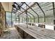 Interior view of the spacious greenhouse, featuring multiple work tables and a glass roof at 123 Eva Ln, Stockbridge, GA 30281