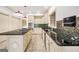 Updated kitchen with black countertops, stainless steel appliances, custom backsplash, and tiled floors at 123 Eva Ln, Stockbridge, GA 30281
