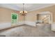 Comfortable living room showcasing neutral tones, a chandelier, and an archway leading to a staircase at 123 Eva Ln, Stockbridge, GA 30281