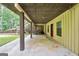 Wide outdoor patio with support beams, wood shed, and red door at 123 Eva Ln, Stockbridge, GA 30281