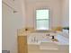 Bright and large white bathtub is surrounded with travertine tiling and built in shelves at 345 Summer Pl, Peachtree City, GA 30269