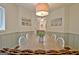 Eat-in dining area boasts charming wainscoting and modern lighting fixtures above a long dining table at 345 Summer Pl, Peachtree City, GA 30269